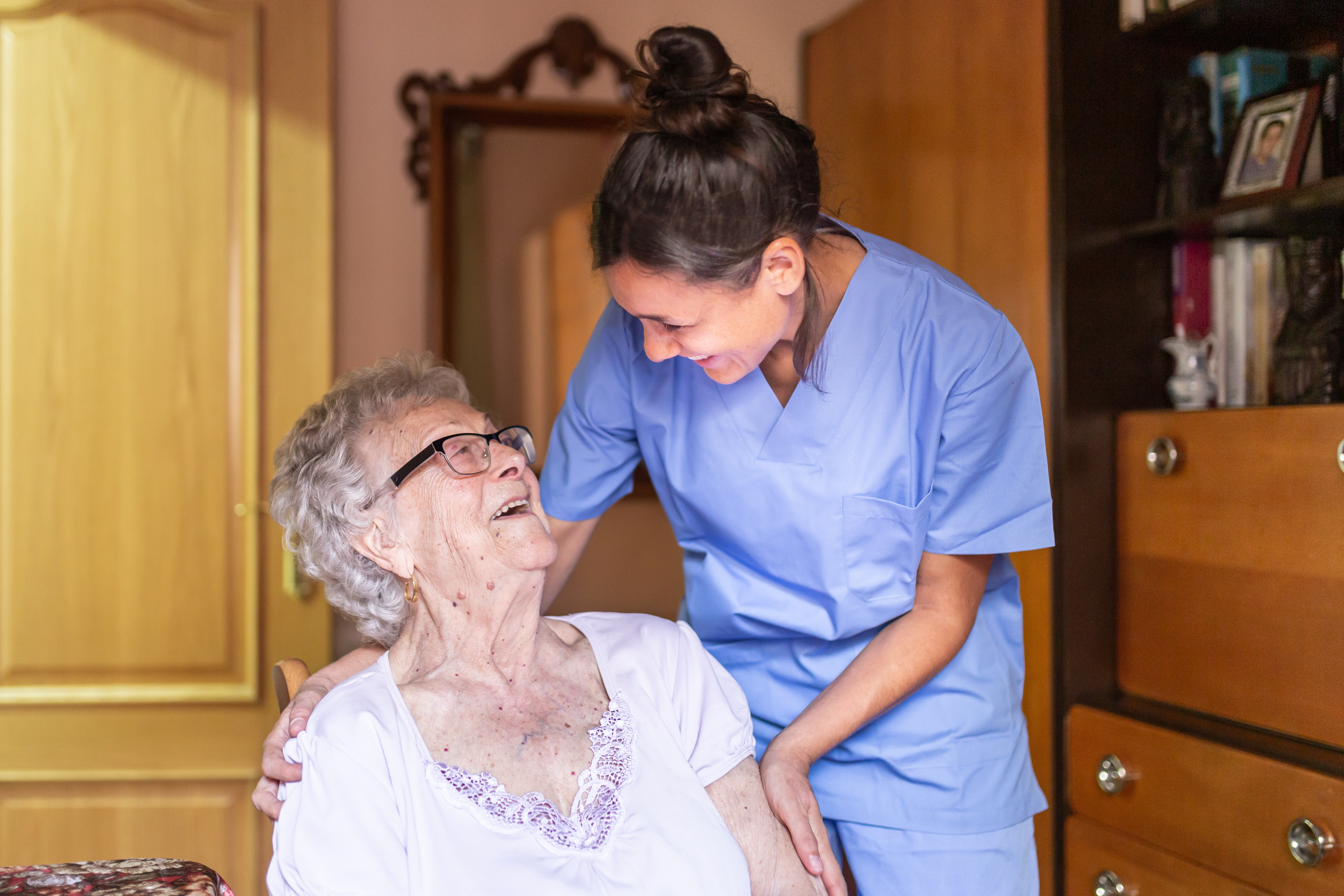 A care worker smiling with an older woman at home