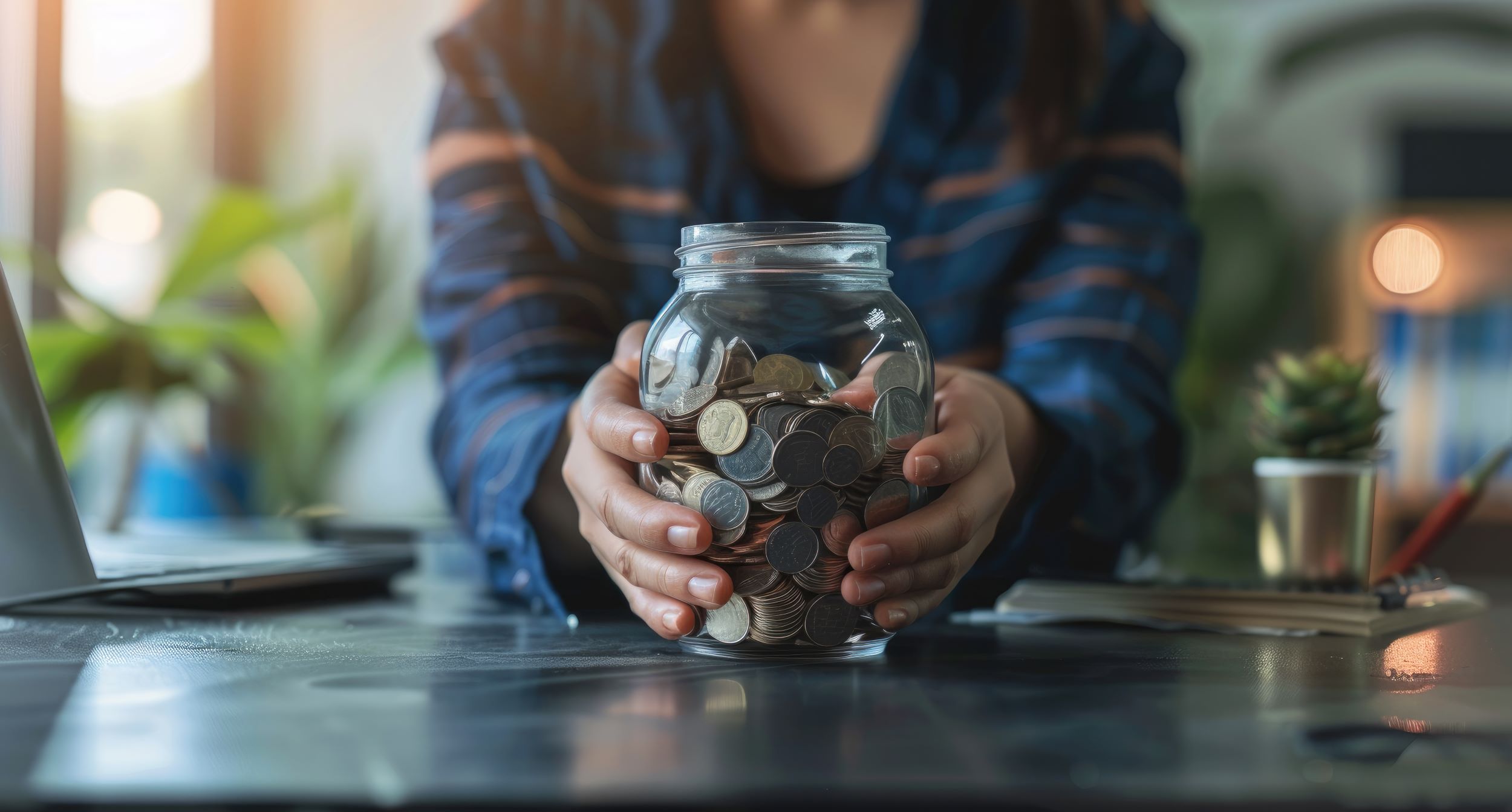 A person holding a large jar of coins